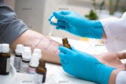 عکس با کیفیت پزشک در حال آزمایش کردن بر روی دست مرد در آزمایشگاه