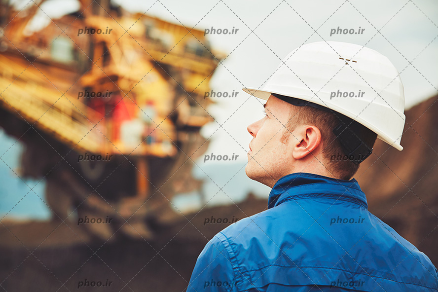 آقای مهندس ساختمان در کنار سازه بزرگ دریایی یا پتروشیمی
