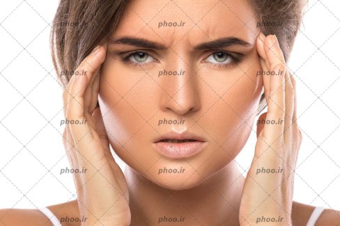 عکس زنی خوشگل با چشم رنگی و چهره ای برافروخته که عضلات شقیقه ی خود را با دست فشار می دهد