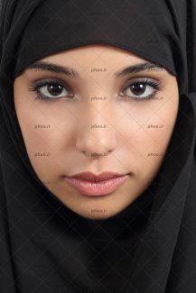 عکس یک خانم با حجاب با روسری مشکی و چشم های قهوه ای و ابرو های باریک که به دوربین خیره شده است
