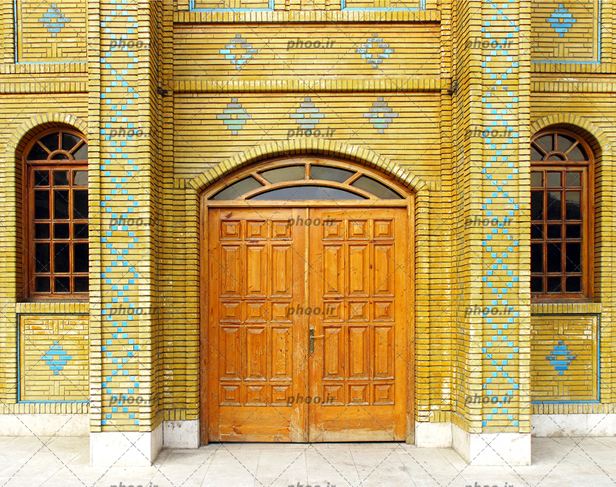 عکس یک در با دو پنجره ی چوبی و نمای آجری