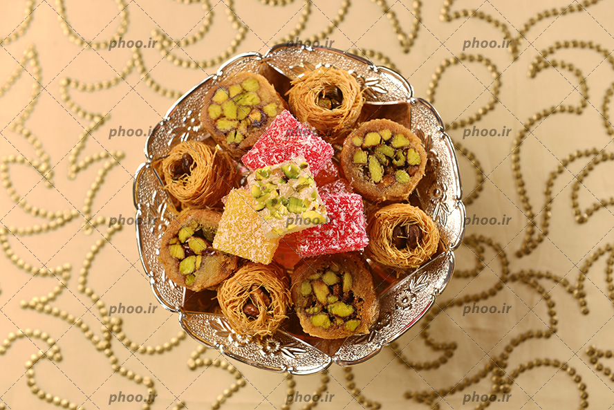 عکس شیرینی و باسلق تزئین شده با مغز در شیرینی خوری نقره ای