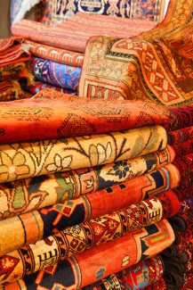 عکس فرش های تا شده روی هم با نقش و رنگ متفاوت