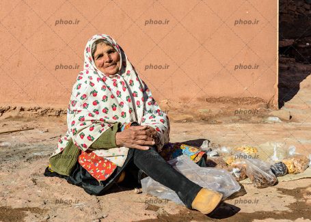 عکس یک خانم دست فروش با تنقلاتی برای فروش