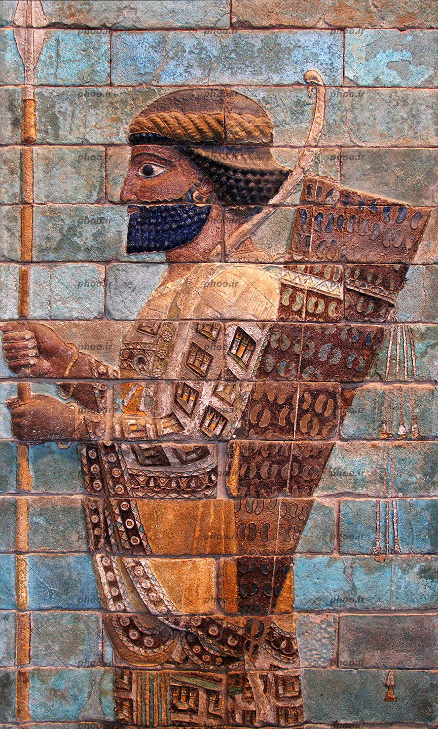 عکس نقش برجسته یک مرد با نیزه و کمان بر دوش روی سنگ