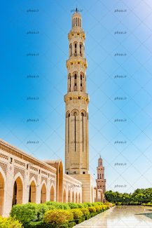 عکس زیبا از گلدسته بزرگ سفید مسجد همراه با آسمان آبی با درختان سبز
