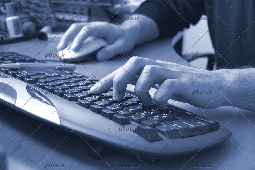 عکس یک مرد در حال کار با صفحه کلید و موس