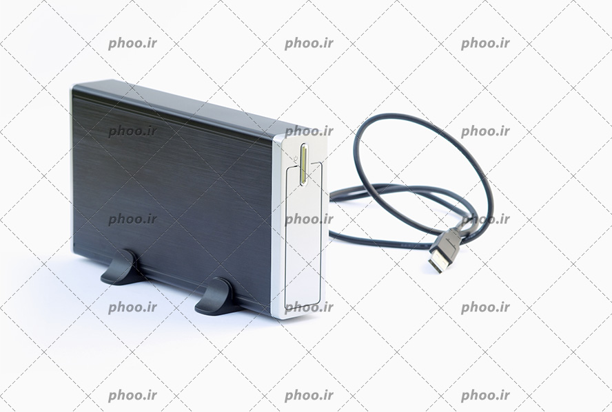 عکس یک هارد اکسترنال نقره ای و یک کابل یو اس بی در کنار آن
