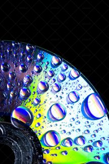 عکس نیمی از یک سی دی با قطره های آب روی آن