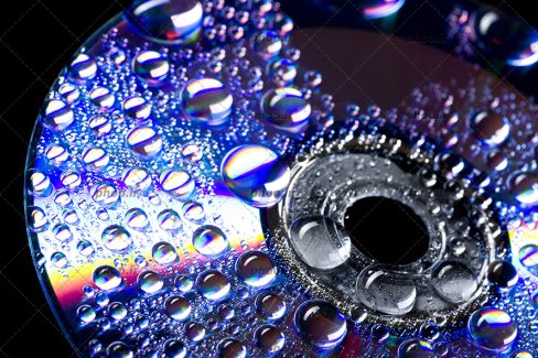 عکس یک سی دی با قطرات آب روی آن در پس زمینه مشکی