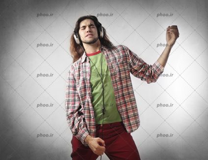 عکس با کیفیت مرد با پیراهن چهارخانه و در حال گوش دادن به موزیک با هدفون