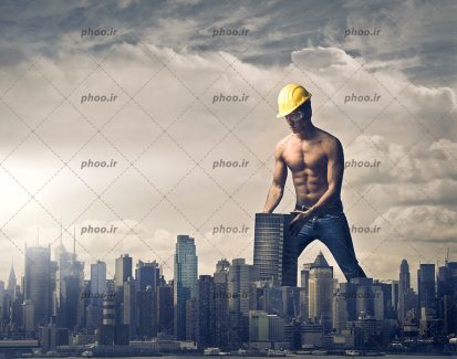 عکس با کیفیت مهندس ساختمان با بدن ورزشکاری در حال جا به جا کردن ساختمان ها