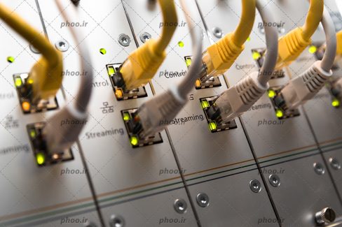 عکس با کیفیت شبکه کابل اترنت سوئیچ از نمای نزدیک و کابل ها به رنگ زرد و سفید