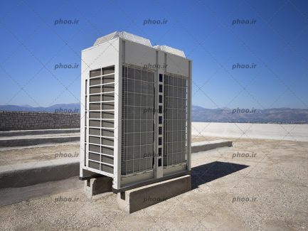 عکس با کیفیت آسمان آبی و کولر گازی بر روی بام ساختمان