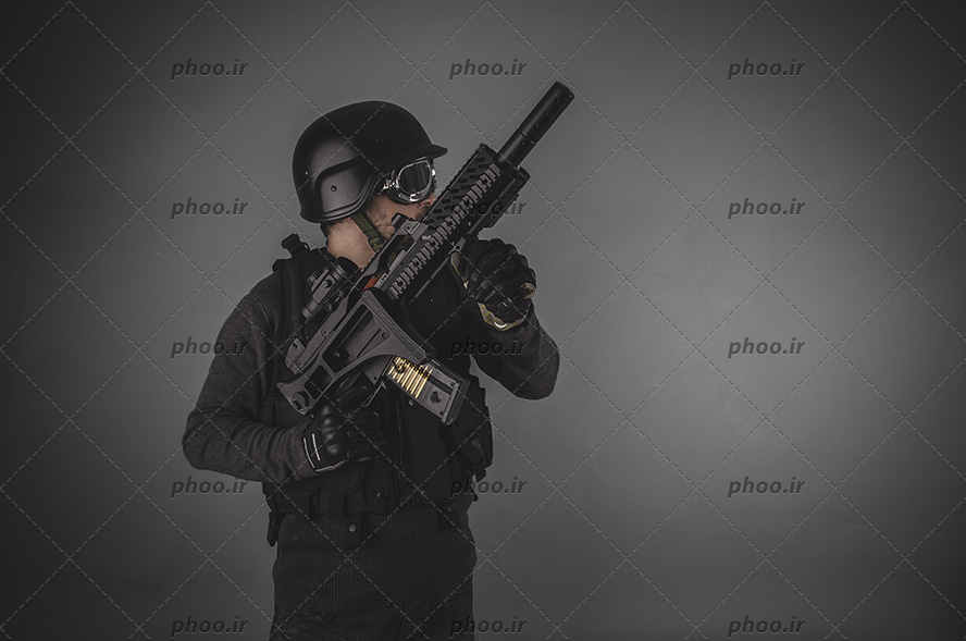 عکس با کیفیت سرباز با لباس مشکی و اسلحه به دست