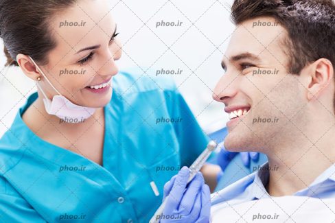 عکس بیمار مرد و دندانپزشک درحال مداوا او