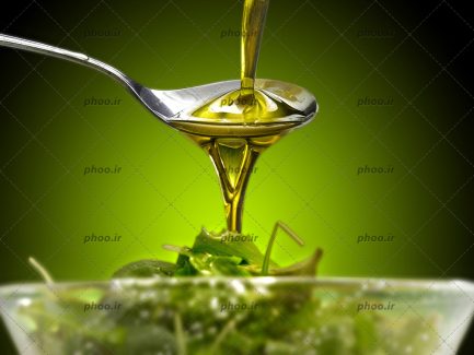 عکس روغن زیتون درحال ریختن در قاشق