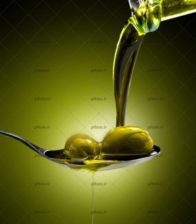 عکس روغن زیتون درحال ریختن روی زیتون ها داخل قاشق