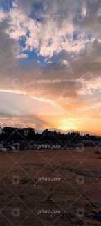 تصویر ساحل و کوهستان و کلبه در شکوه غروب