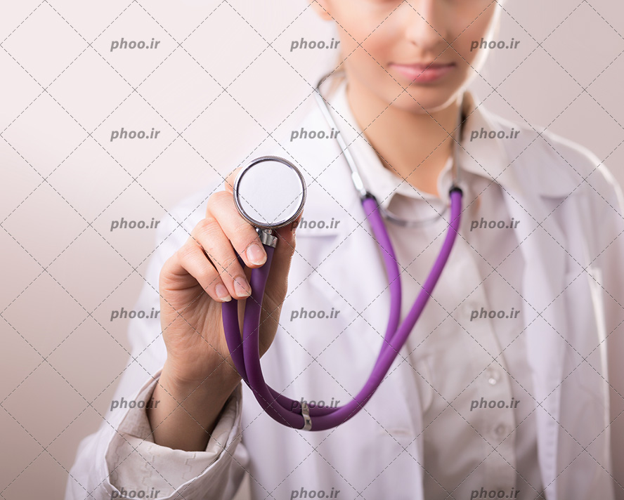عکس با کیفیت استتوسکوپ به رنگ بنفش در دست پزشک با روپوش سفید