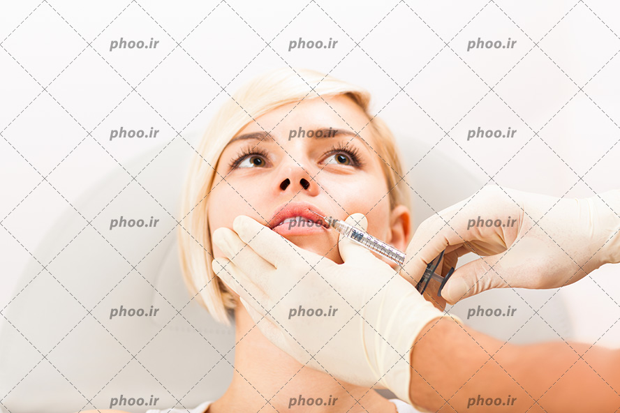 عکس با کیفیت پزشک در حال تزریق ژل به لب های زن