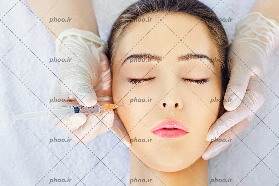 عکس با کیفیت سرنگ در دست پزشک و پزشک در حال تزریق ژل به گونه زن