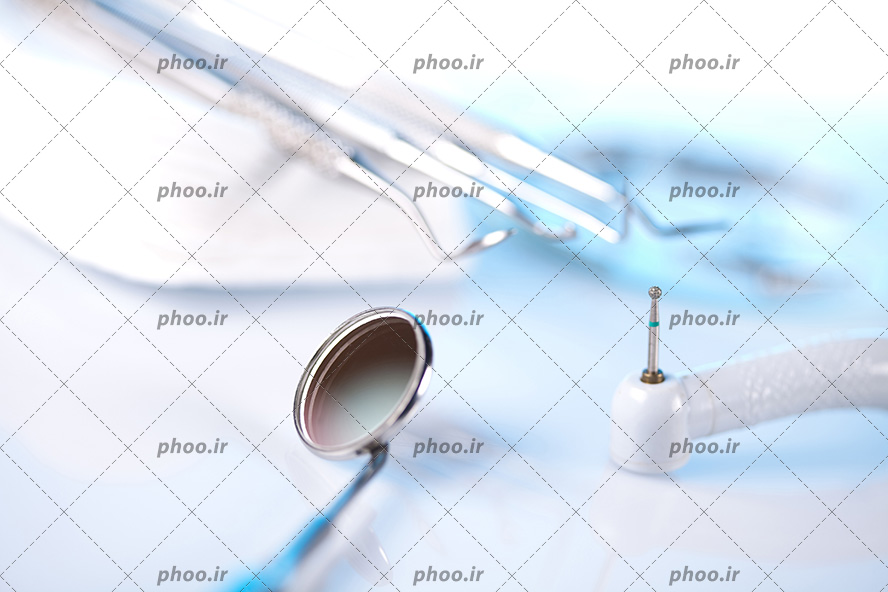 عکس با کیفیت آینه مقعر در کنار دیگر تجهیزات دندانپزشکی از نمای نزدیک