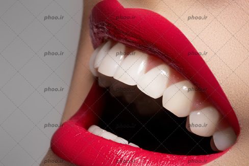 عکس با کیفیت زن با لب های باز و قرمز و دندان های سفید و درخشان در حال خندیدن