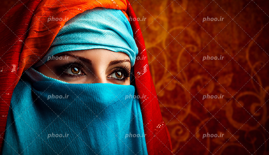 عکس با کیفیت زن با چشم های زیبا و پوشاندن سر و صورت خود با شال آبی و قرمز