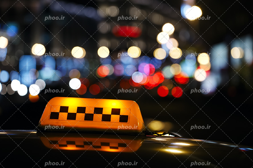 عکس با کیفیت چراغ روشن با نور زرد بر روی سقف تاکسی در شب