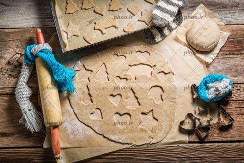 عکس کلوچه های شیرینی زنجبیلی کریسمس ایجاد شده با قالب های متفاوت روی خمیر از نمای بالا