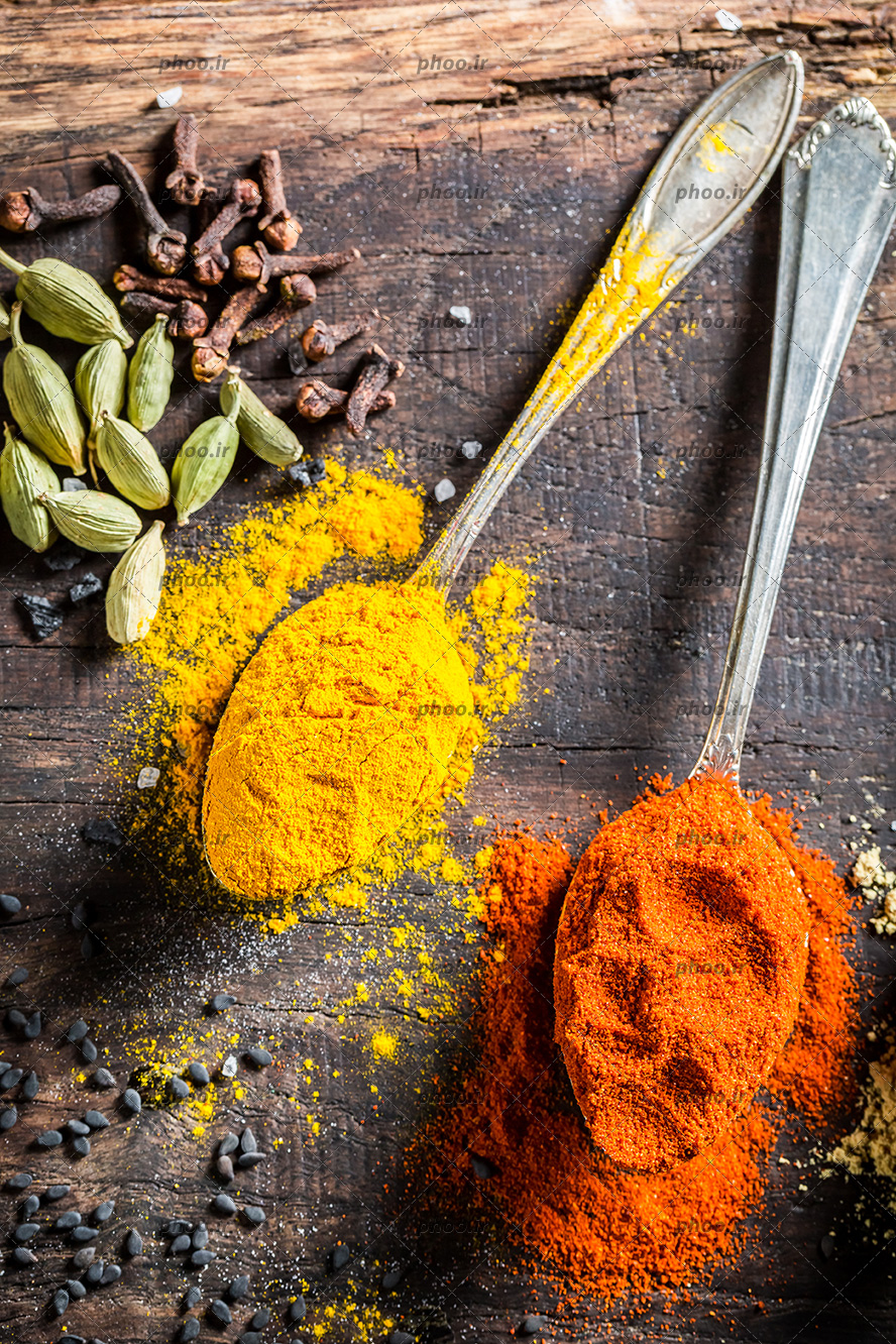 عکس ادویه و گیاهان متفاوت در پس زمینه چوبی