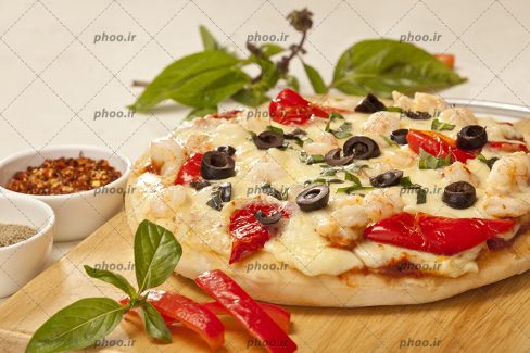 عکس پیتزای داغ روی تخته چوبی
