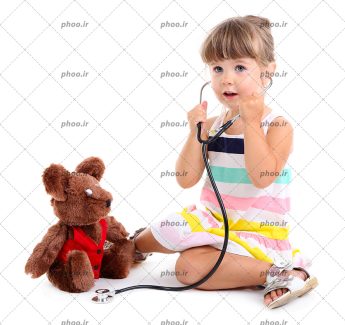 عکس با کیفیت دختر بچه با گوشی پزشکی در حال بازی با عروسک خرسی