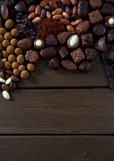 عکس شیرینی های شکلاتی و کاکائویی با شکل های متفاوت زیبا در پس زمینه چوبی