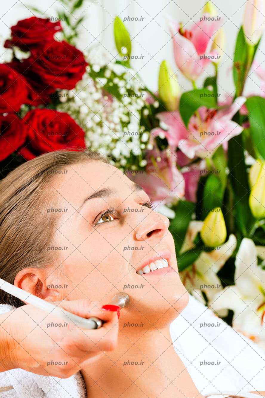عکس زن درحال پاکسازی صورت با زمینه گل ها