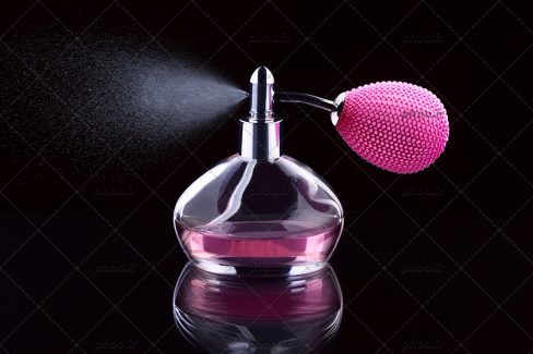 عکس ادکلن صورتی درحال اسپری در زمینه مشکی