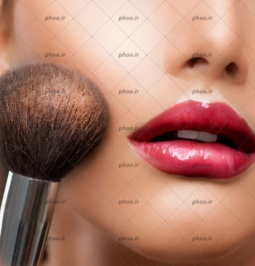 عکس لب های رژ قرمز زده و براش درحال میکاپ