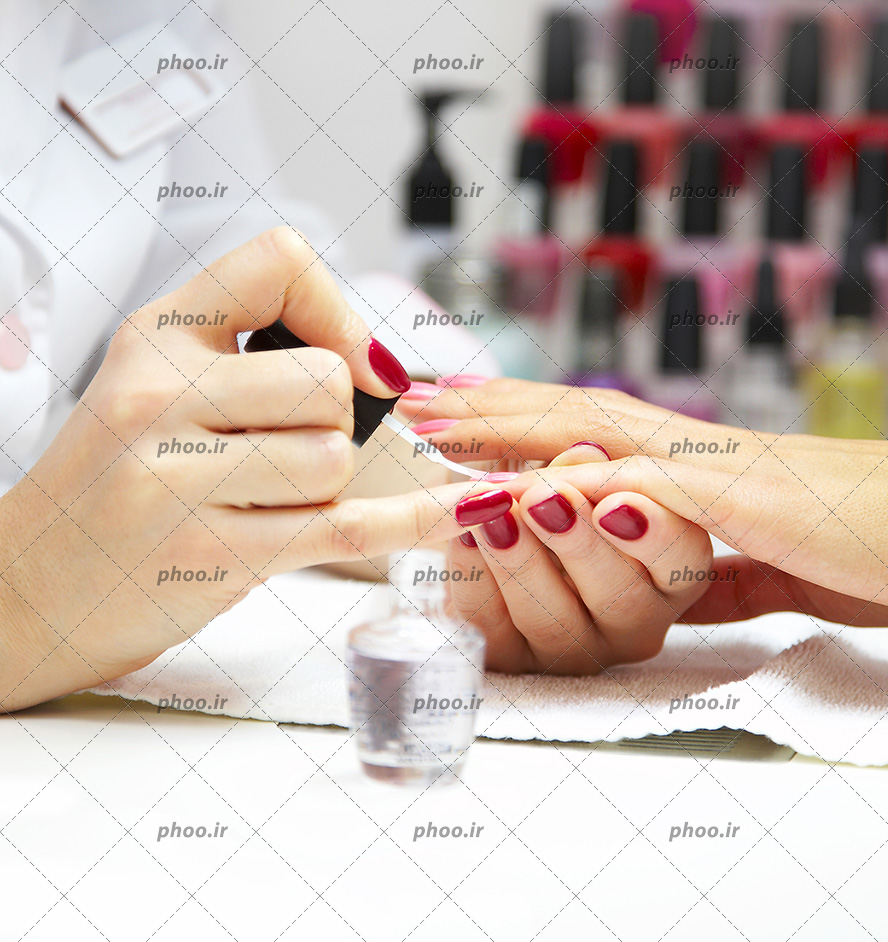 عکس ناخن کار درحال مانیکور کردن و لاک زدن دست