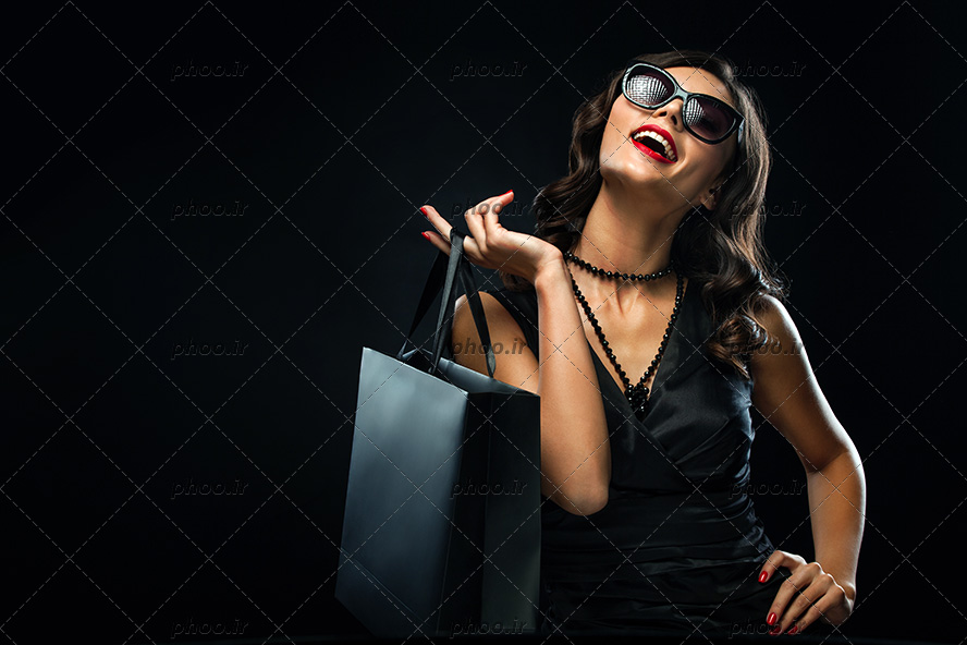 عکس زن عینکی خوشحال با سبد و بسته های خرید تم مشکی
