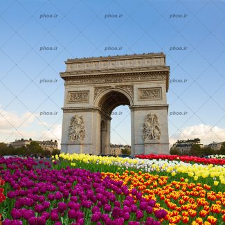 عکس زیبا دروازه با سازه تاریخی و گل های رنگارنگ واسمان ابی و خیابان