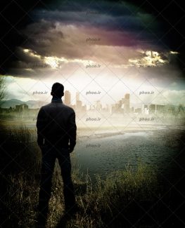 عکس با کیفیت مرد ایستاده از پشت در کنار دریاچه در حال نگاه کردن به شهر