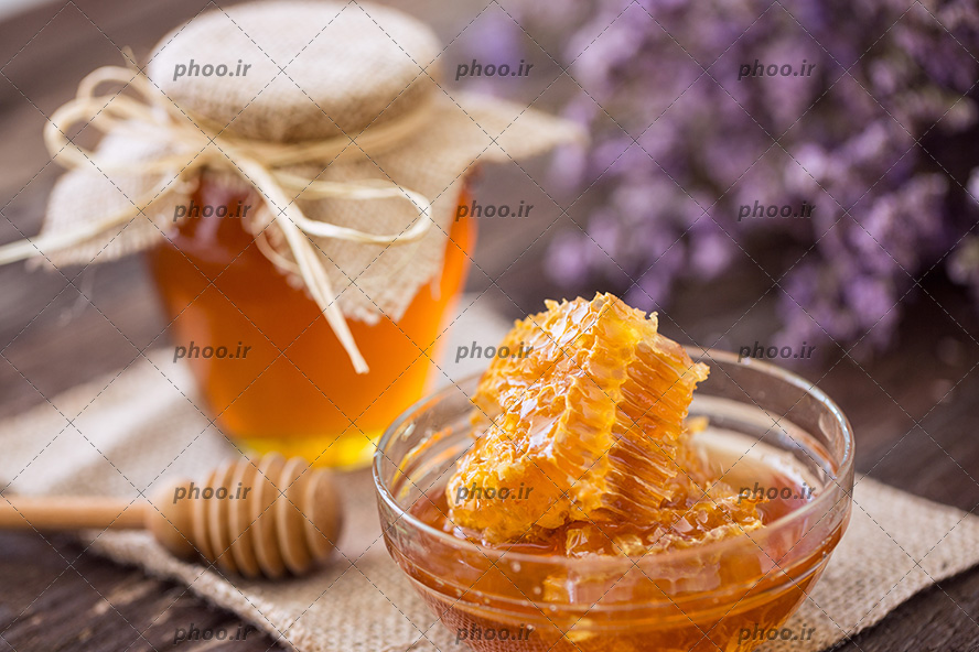 عکس عسل طبیعی در ظرف و کاسه شیشه ای در کنار قاشق چوبی