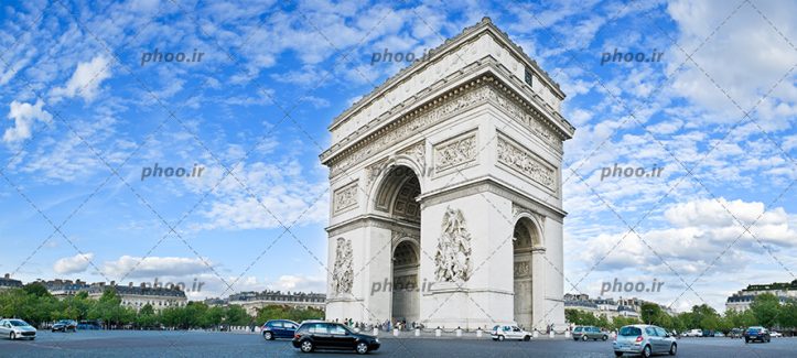 عکس زیبا سازه تاریخی با اسمان ابی و ابر با خیابان پر از ماشین و درخت