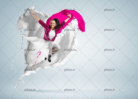 عکس با کیفیت خانم شاد در حال پریدن از میان رنگ های صورتی و سفید