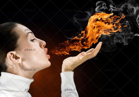 عکس یک زن که از دهان خود آتش میدمد در پس زمینه سیاه