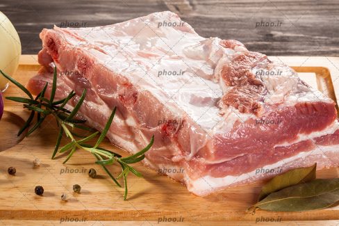 عکس گوشت خام از نمای نزدیک روی تخته چوبی