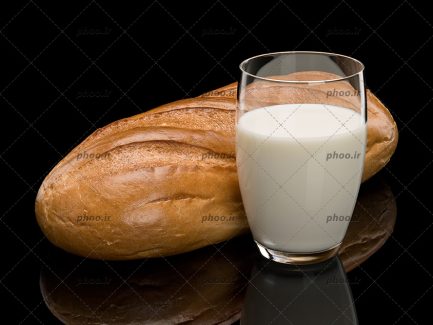 عکس لیوان شیر در کنار نان باگت در پس زمینه مشکی