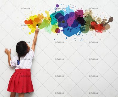 عکس با کیفیت دختری با قلم مو نقاشی در دست در حال نقاشی کردن روی دیوار سفید