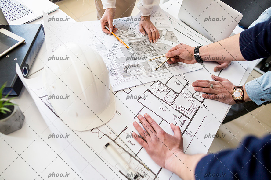 عکس با کیفیت مهندسین در حال برسی نقشه های ساختمان